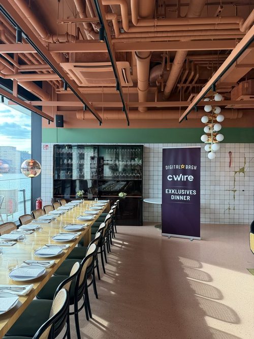 Langer Tisch im Restaurant, daneben ein Roll-up