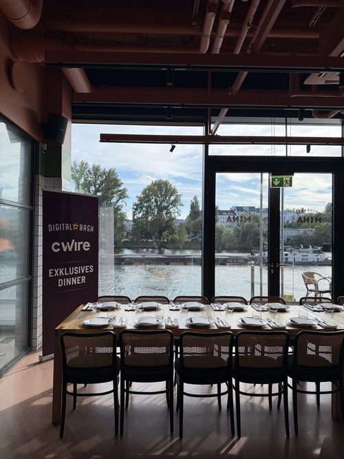 Gedeckte Tafel vor der Fensterfront zum Wasser